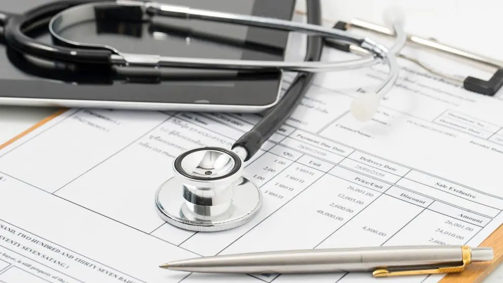 insurance forms with a pen and tools on top
