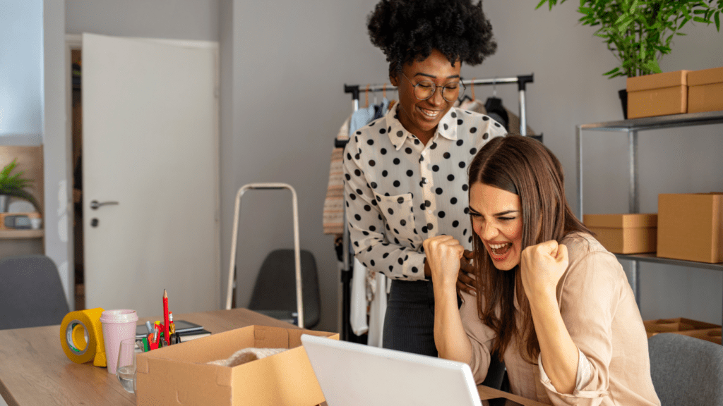 Two women excited about something on computer